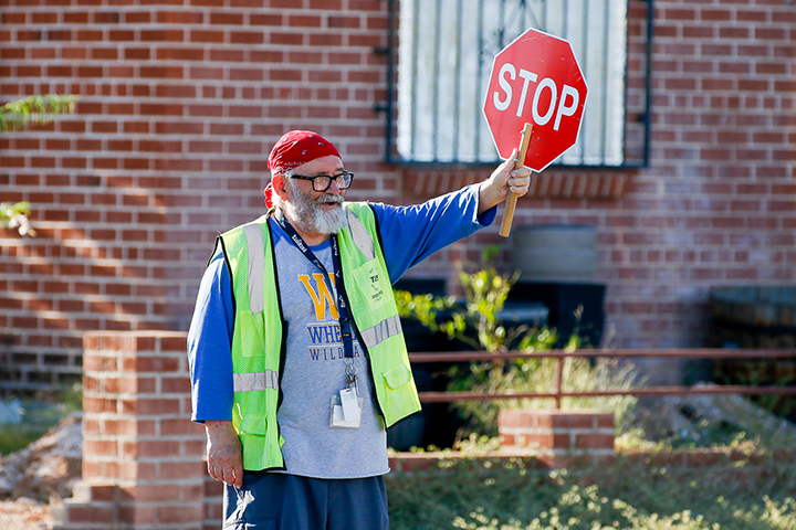 A crossing guard holds up his stop sign