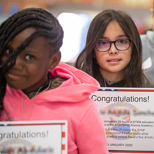 Two students displaying awards